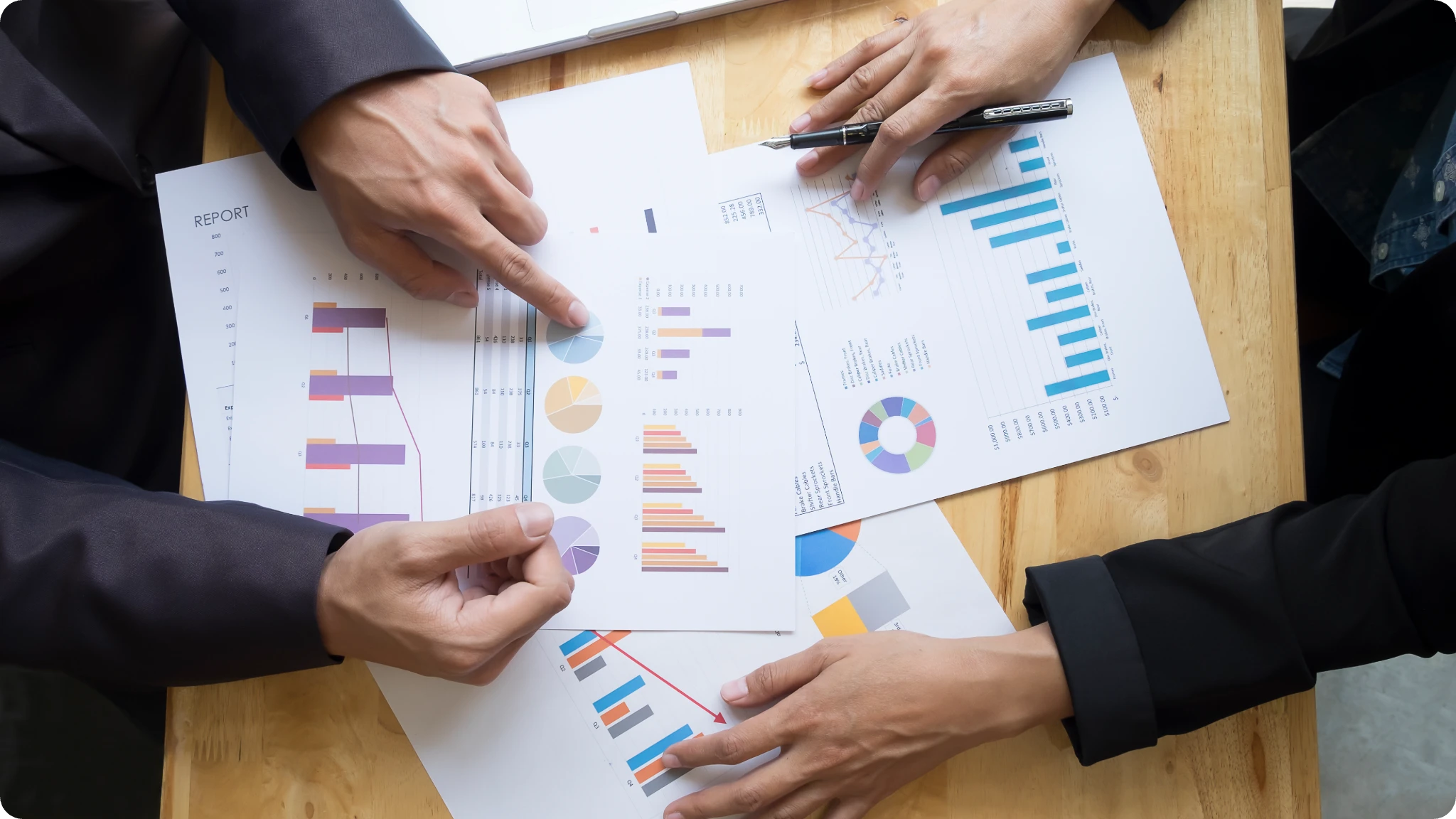 Zwei Menschen diskutieren und markieren auf dem Tisch eine Papierakte